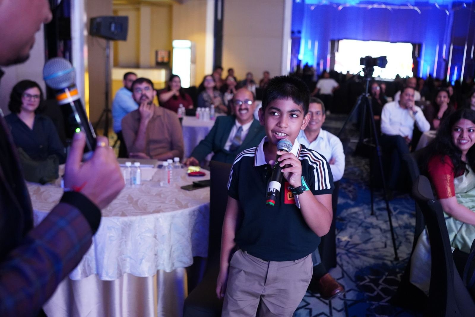 A young attendee sharing his thoughts with the mic